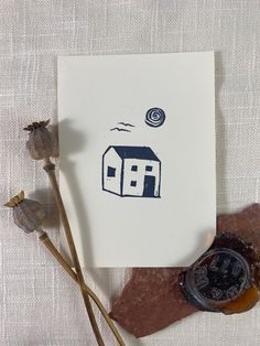 a piece of paper sitting on top of a table next to some dried flowers and a wax stamp