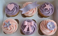 cupcakes with pink and purple frosting in a box