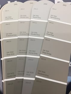 several shades of gray and white paint on display