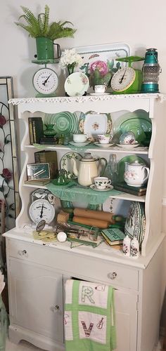 an old china cabinet is filled with dishes and other items, including plates and clocks