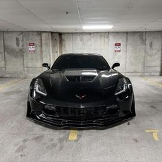 a black sports car parked in a parking garage