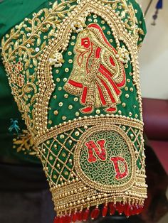 an elaborate green and gold hat with red beads on it's headdress