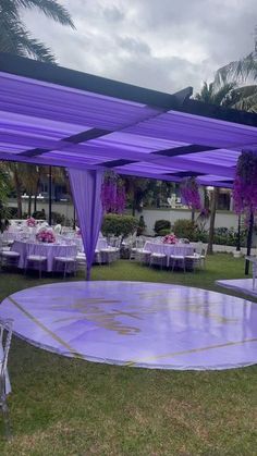 an outdoor wedding setup with purple draping