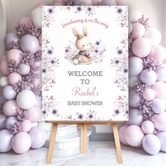 Celebrate the upcoming arrival of your little girl with this cute baby shower Welcome Sign Foam Board Poster featuring an adorable baby bunny girl in soft purple flowers and pink & purple text on the white background. This sign is perfect for a charming spring-themed girl baby shower. Easily personalize all the details - Kate Eden Art Purple Baby Shower Theme, Flower Baby Shower Theme, Bunny Baby Shower Theme, Spring Baby Shower Themes, Purple Text, Lavender Background, Baby Shower Purple, Bunny Baby Shower, Spring Baby Shower