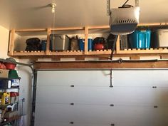 a garage with two overhead storage racks and several containers on top of the garage door