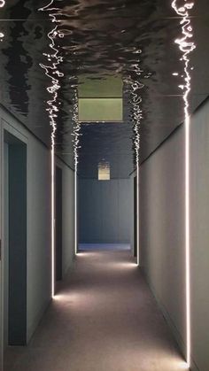 an empty hallway with lights on the ceiling