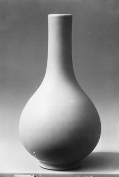 a large white vase sitting on top of a table