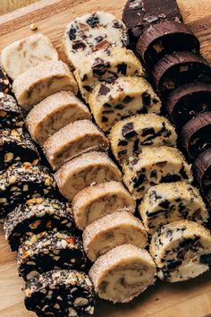 a wooden cutting board topped with different types of desserts