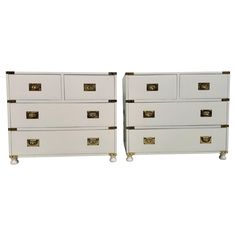 a pair of white chests with brass handles