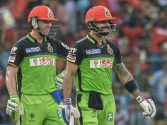 two men in green and red uniforms standing next to each other with their hands on their hips