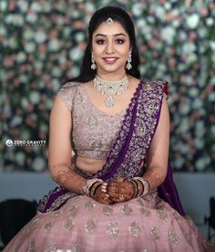 a woman in a pink and purple lehenga