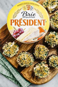 a wooden cutting board topped with cheese and broccoli covered mini muffins