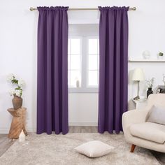 a living room with purple curtains and white furniture