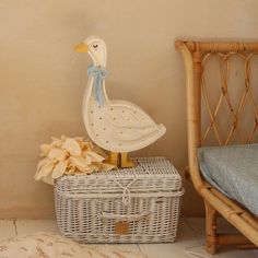 a white duck figurine sitting on top of a basket next to a bed