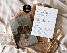 an image of a wedding announcement on a wooden plate with flowers and rings next to it