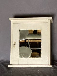 a mirror that is on the side of a wall next to a shelf with items in it