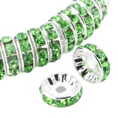 green crystal beaded spacer beads with silver plated clasps on white background