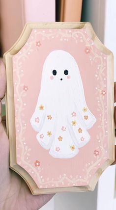 a person holding up a painting with a ghost on it