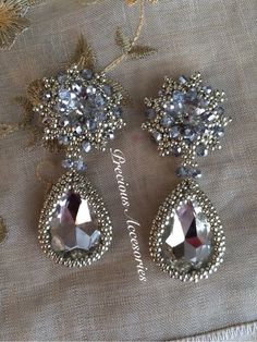 two pairs of earrings on top of a piece of cloth