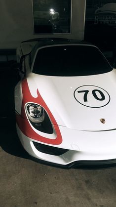 a white and red sports car parked in a garage