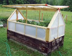 an old wooden greenhouse with plants growing in it