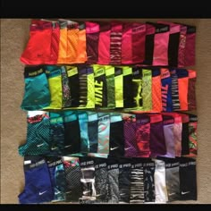 many pairs of nike socks laid out on the floor in rows, all different colors and sizes