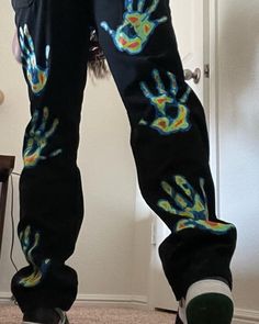 a person standing in front of a door with their hands painted on it's pants