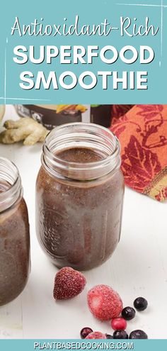 two jars filled with smoothie next to berries