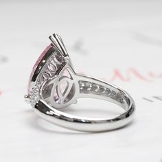 SKU : HCHB15R0318A This beautiful Sterling Silver Pear Cut 5.75 Carat Super Light Pink CZ 15.5 mm Cocktail Ring is a meticulously crafted and beautiful ring. PINK: Cherished for its emotional healing power and promoting the feeling of love and happiness, this romantic ring showcases a 5.75 carat pear cut pink with pave set band to give that extra sparkle. PEAR CUT: The elongated silhouette of this cut makes your fingers look slender and elegant. What's more, you can wear it with the point facing Gia Certified Teardrop Ring For Anniversary, White Gold Teardrop Jewelry For Proposal, Silver Teardrop Gia Certified Ring, Gia Certified Silver Teardrop Ring, Silver Halo Teardrop Rings, Gia Certified Teardrop Jewelry For Anniversary, Silver Teardrop Halo Rings, Gia Certified Pear-shaped Promise Ring, Pear-shaped Morganite Jewelry