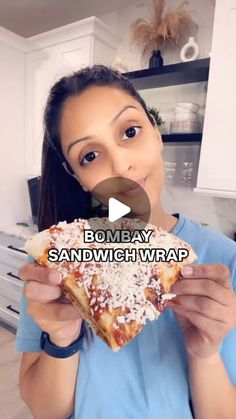 a woman holding up a piece of pizza in her hands with the caption bombay sandwich wrap