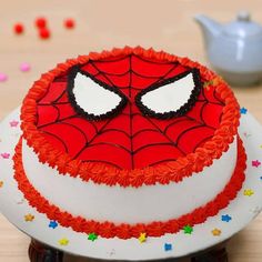 a spiderman cake on a table with sprinkles