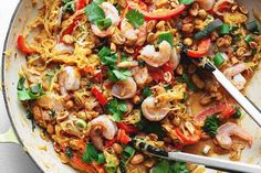 a skillet filled with shrimp, rice and veggies