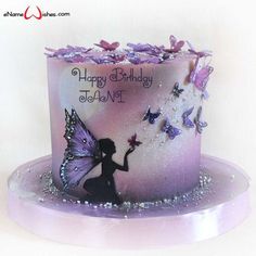 a cake decorated with purple butterflies and a fairy holding a butterfly on it's side