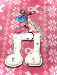 a keychain with a musical note charm hanging from it's side on a pink background