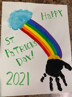 a child's hand with a rainbow painted on it that says happy st patricks day