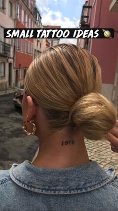 the back of a woman's head with a small tattoo on her left ear