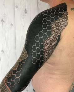 a man with a tattoo on his arm and shoulder that has hexagonal shapes