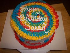 a birthday cake with the words happy birthday sandy on it's top and rainbow icing