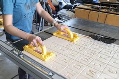 a woman is making letters on a machine