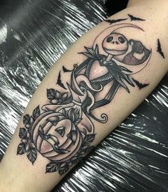 a black and white tattoo on the arm of a person with a rose in front of it