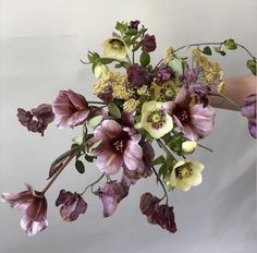 a woman holding a bouquet of flowers in her hand with the stems still attached to it