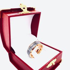 an open red box with two wedding rings in it