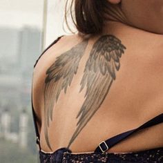 the back of a woman's shoulder with an angel tattoo on it