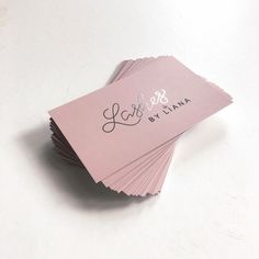 some pink cards with the word love written on them are sitting on a white surface