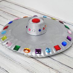 a paper plate that has some kind of hat on it with colored stones in the middle