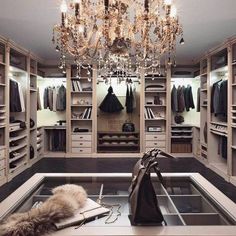 an open closet with a chandelier hanging from the ceiling