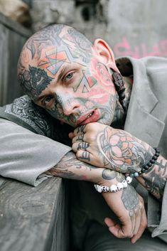 a man with lots of tattoos on his face