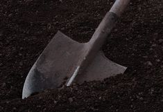 a shovel in the ground with dirt around it