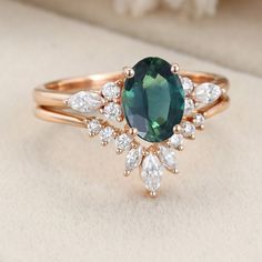 a ring with an oval green stone surrounded by white and clear stones on top of it