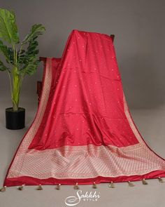 Cherry red charm abounds in the mashru silk tanchoi Banarasi, its dainty zari polkas twinkling like secret kisses across the fabric. The zari border and pallu shimmer with subtle sophistication, as the tonal blouse's soft sheen complements the saree's lively drape. This vibrant ensemble is a celebration of joy, weaving playfulness and elegance into every thread, draping the wearer in a delightful, whimsical glow. * Banarasi katan silk saree for special occasions. * Crafted from the premium quality fabric. * Supplied with a readymade blouse. * The blouse comes with an added allowance, and it can be altered to a standard size of 34"-42" on request. * Dry clean only to maintain colour and quality. Note: Colors may slightly vary due to photographic lighting. We provide same day shipping for or Banarasi Katan Silk Saree, Red Charm, Katan Silk Saree, Katan Silk, Readymade Blouse, Saree With Blouse, Photographic Lighting, Cherry Red, Silk Saree